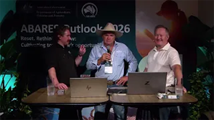 Three people sitting at a table in front of laptops