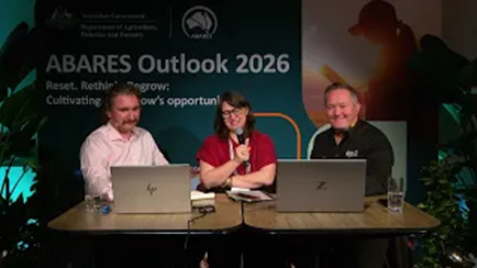 Three people sitting at a table in front of laptops