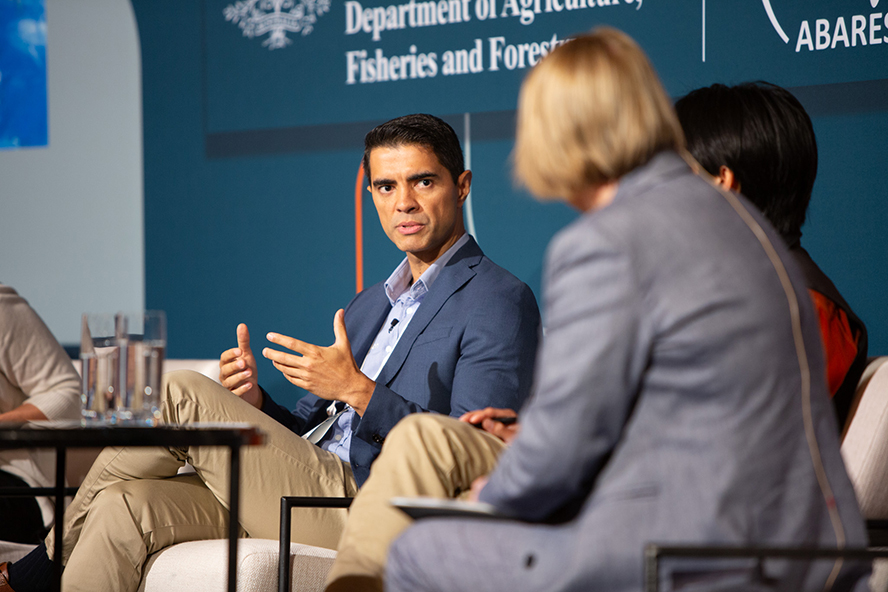 Three people sitting on a stage in conversation