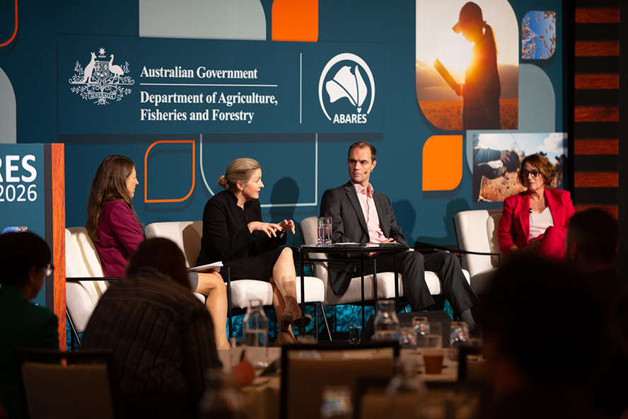 Four people sitting on a stage in conversation