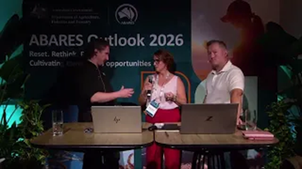 Three people sitting at a table in front of laptops