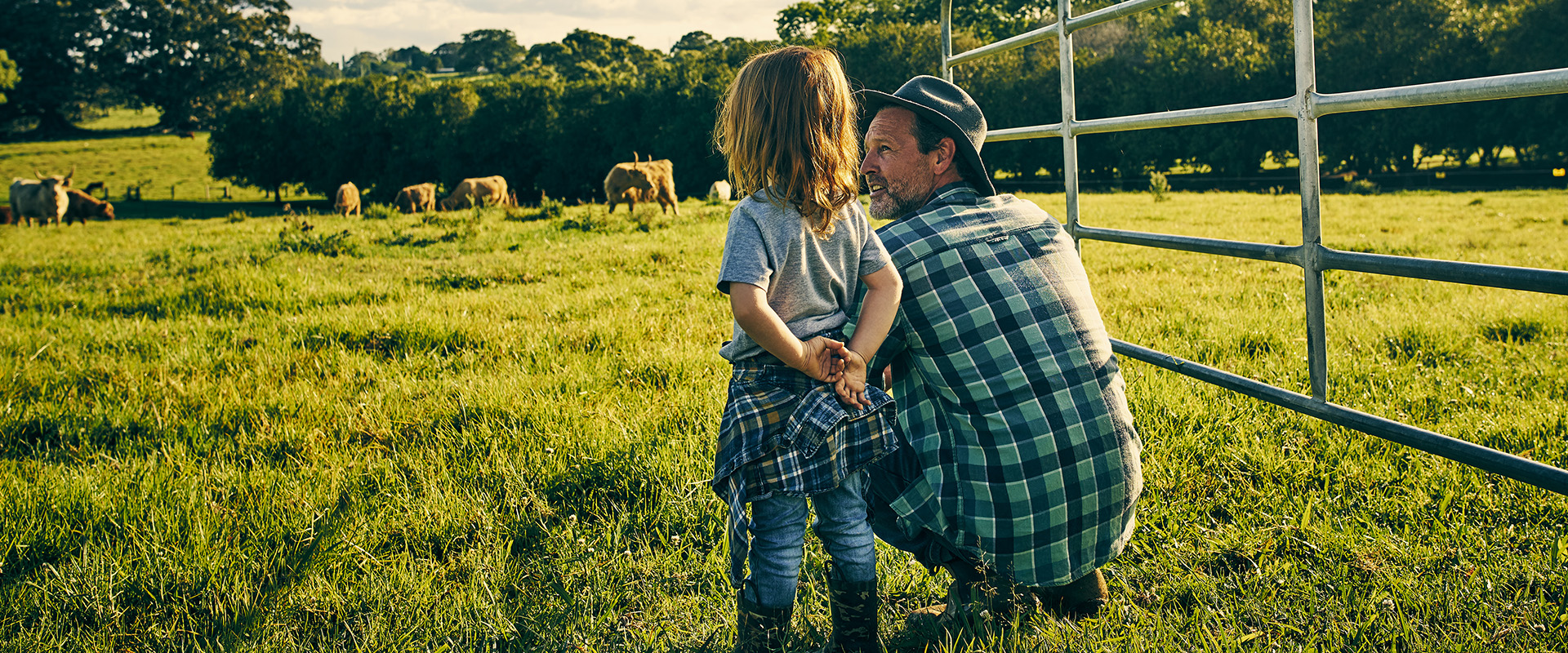 Farmer and child in a field at sunset