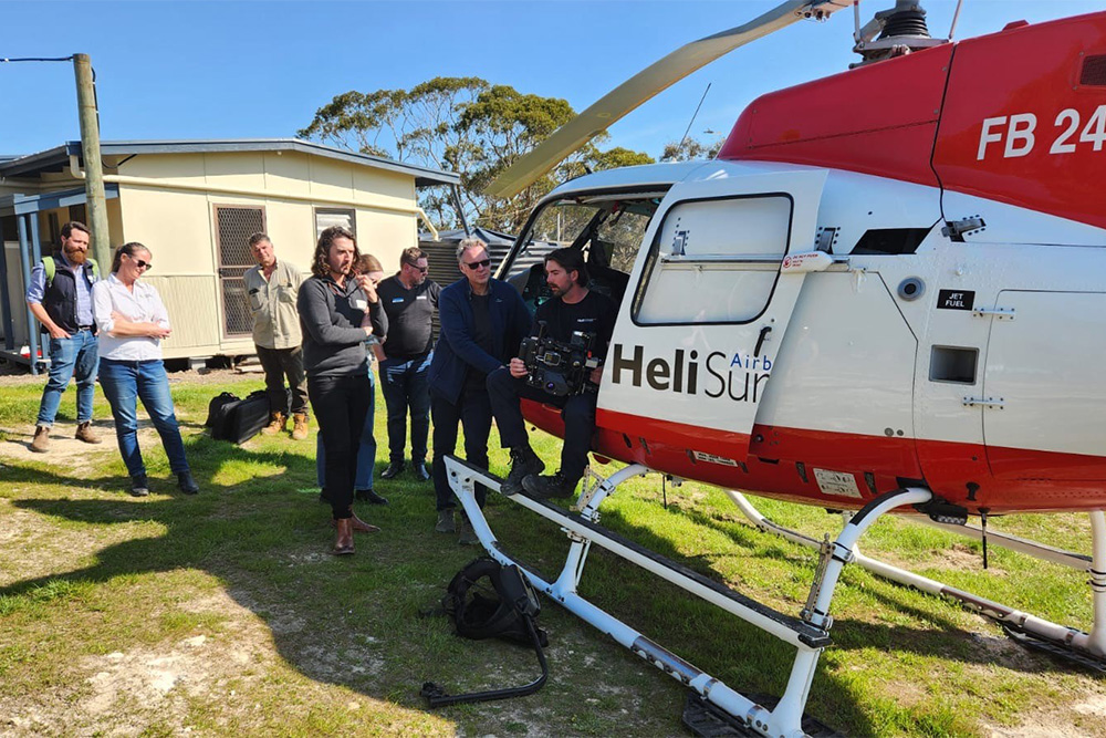 Image of a group of people standing around a helicopter