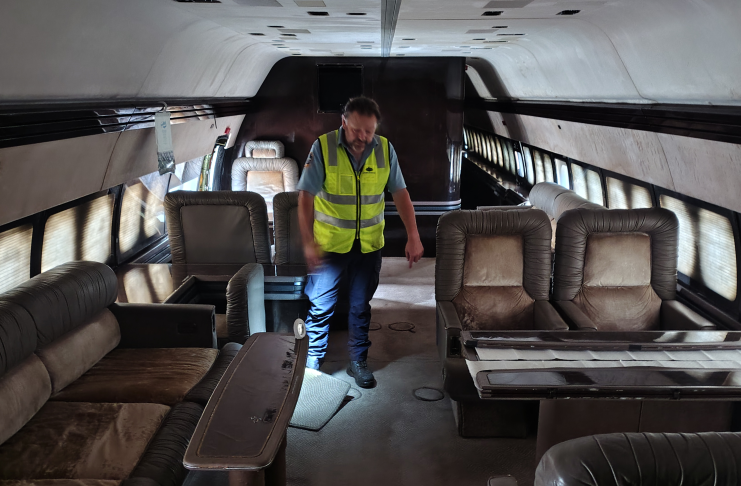 A person in a high visibility vest inspecting seats in a vehicle