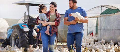 A poultry farmer and his family with a large number of chickens