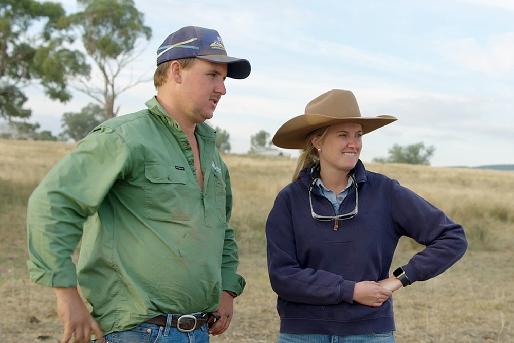 Two people standing in a paddock