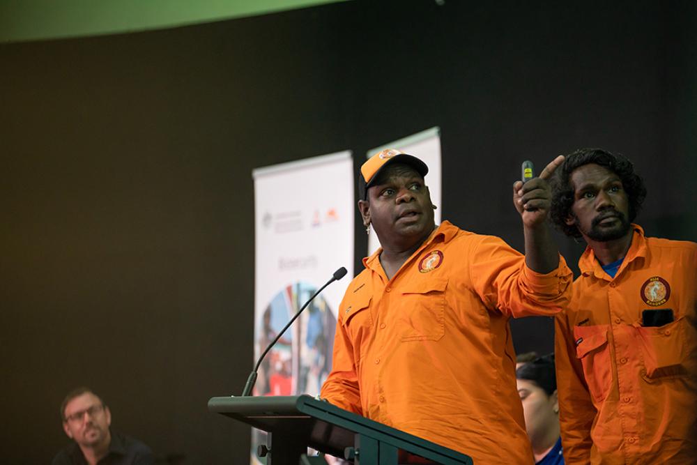 Image of a person standing at a podium delivering a speech