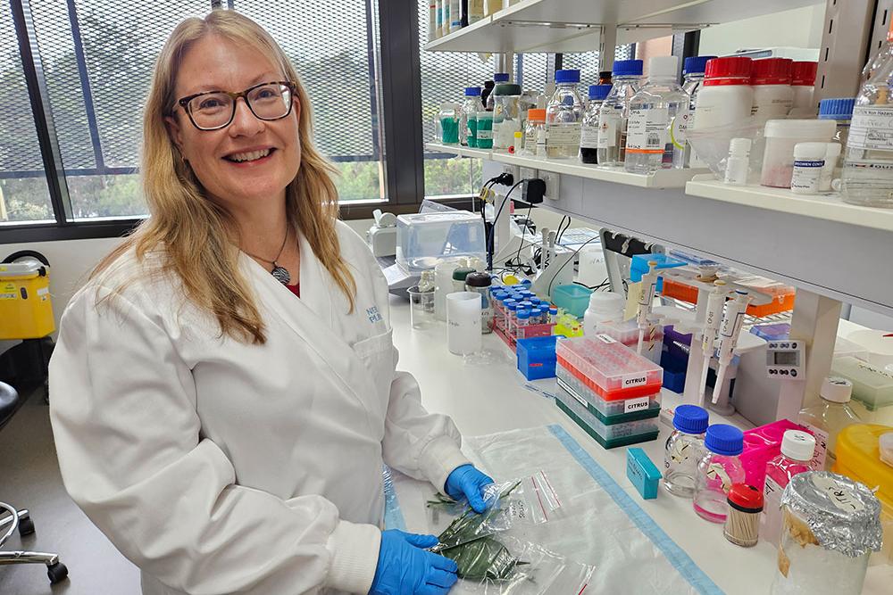 Dr Nerida Donovan in lab coat and gloves
