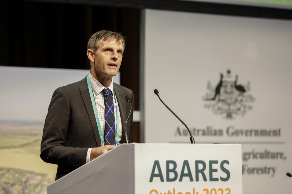 Image of a person standing at a podium delivering a speech