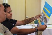 2 First Nations biosecurity students work on an information campaign poster