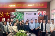 Staff from Vietnam’s Plant Production and Protection Department and DAFF’s International Capacity Development team standing in front of a screen and banner containing Vietnamese writing