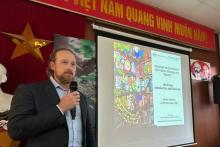 International Capacity Development director standing next to a presentation screen, facilitating a biosecurity workshop in Vietnam